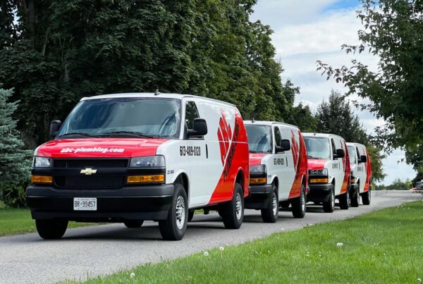 A full fleet wrap for ABC Plumbing Chevrolet Express vans in Ottawa, designed for consistency and branding across multiple vehicles.